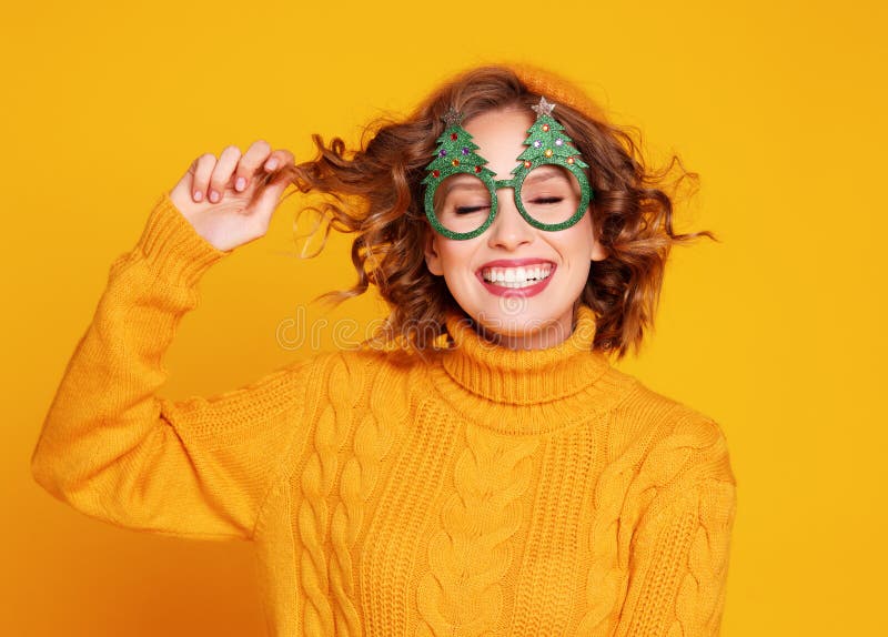 Delighted woman in Christmas glasses touching hair