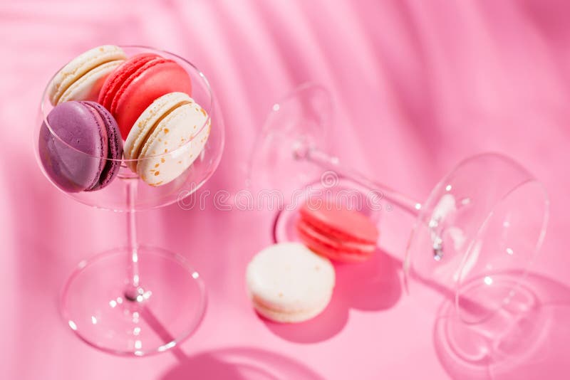 A delightful assortment of colorful macaroons arranged on a vibrant pink background stock photo