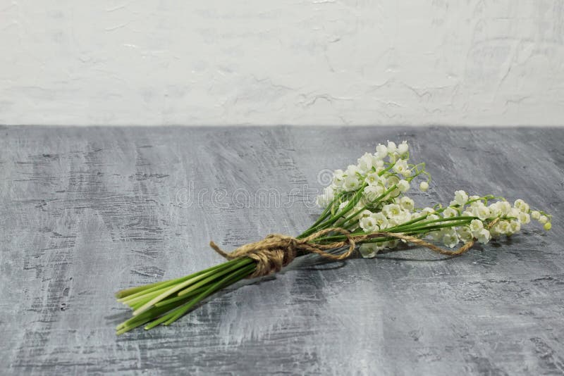 Mood and feelings. Bouquet of delicate spring lily of the valley on dark concrete. Mood and feelings. Bouquet of delicate spring lily of the valley on dark concrete.