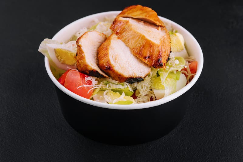 Delivery Bowl with Caesar Salad Isolated on Black Stock Photo Image