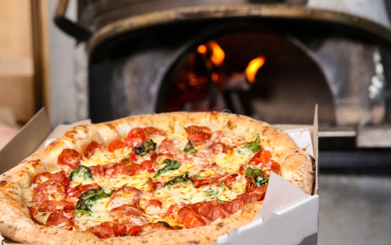 Delivery Box with Tasty Italian Pizza Near Oven in Restaurant Stock