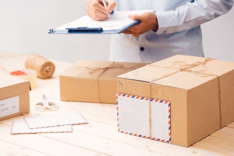 Delivery concept. Man signs papers among parcels stock images