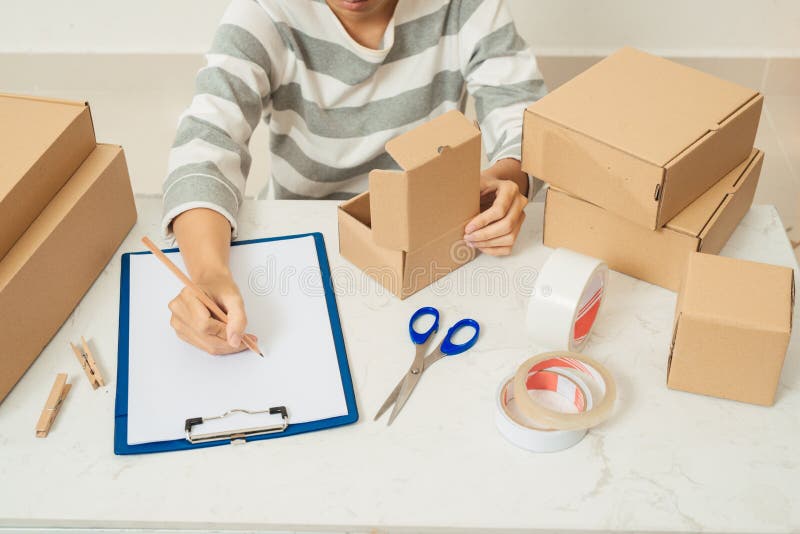 Delivery concept. Woman signs papers among parcels, close up royalty free stock image