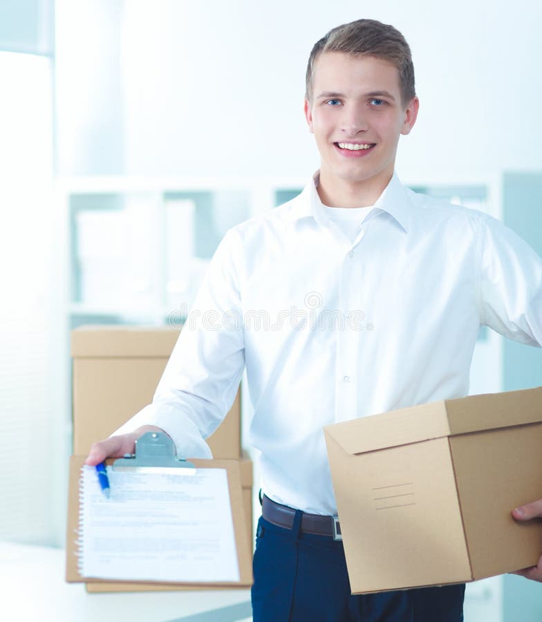 Delivery Man with Parcel and a Tablet Standing in Office Stock Photo - Image of uniform, tablet ...