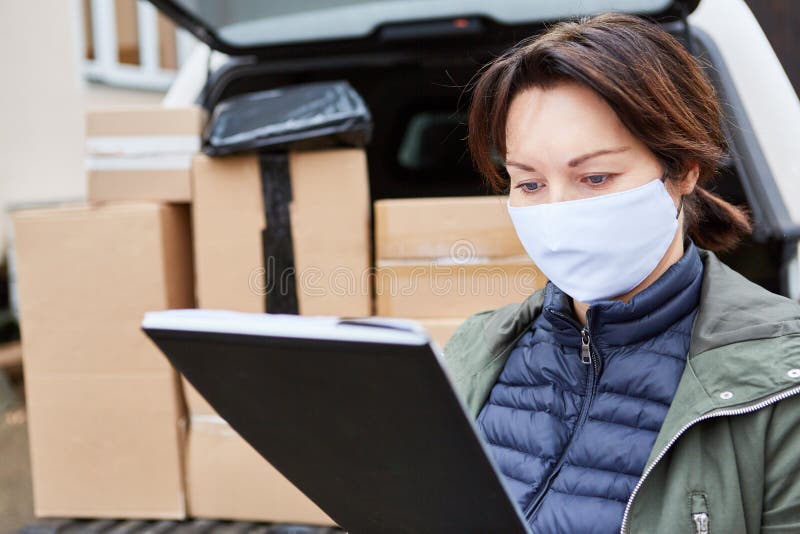 Delivery Service with Face Mask Checks Deliveries in Front of the Hold