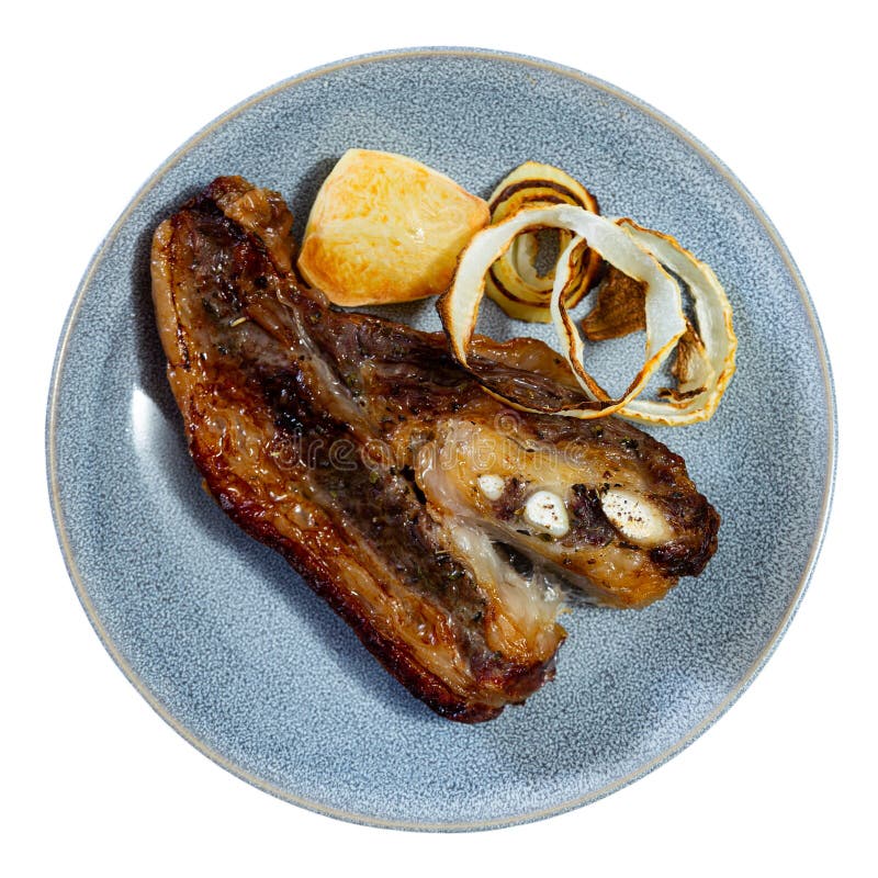 Deliziosa bistecca di manzo con cipolle fritte sul tavolo da pranzo immagine stock