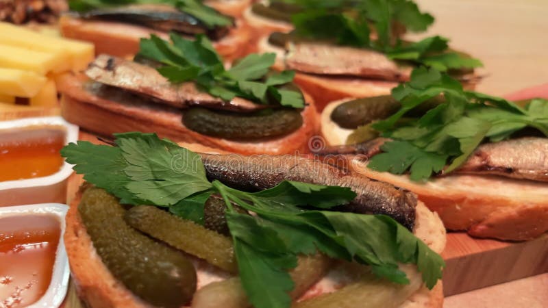 Deliziosi snack da festa. vista macro di petti di baguette con spratto di pesce e sottaceti. vassoio con antipasto. chiusura archivi video