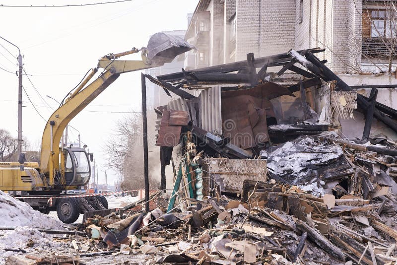 Demolition house. Building renovation at city. Industrial breaker