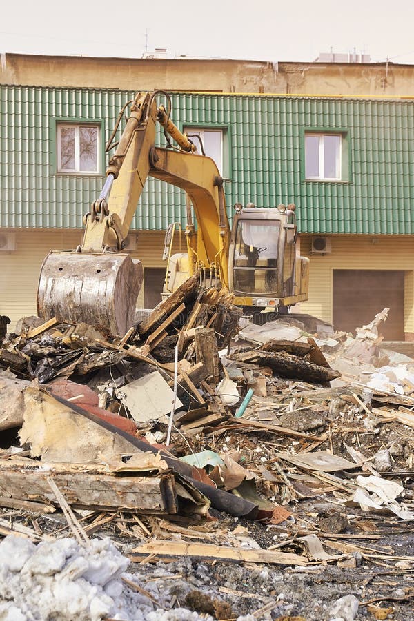 Demolition house using excavator in city. Rebuilding process. Remove equipment stock photo