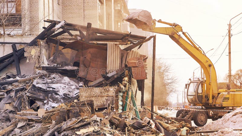 Demolition house using excavator in city. Rebuilding process. Remove equipment royalty free stock photos