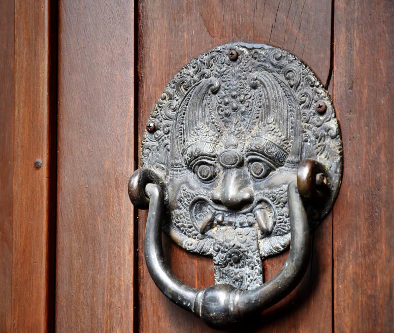 Demon balinez ciocănitură bronz pe fond de lemn stock photos
