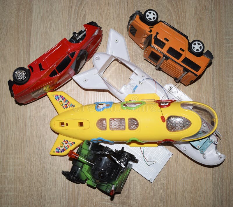 Demonterade bilar och flygplan för en leksak som delas i flera stycken på träskrivbordet royaltyfri fotografi Demonterade bilar och flygplan för en leksak som delas i flera stycken på träskrivbordet royaltyfri fotografi