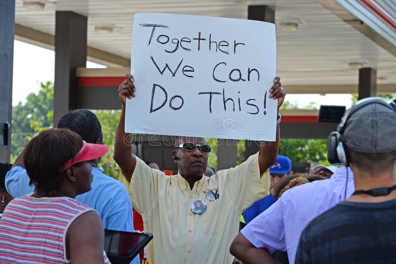 FERGUSON, MO/USA â€“ AUGUST 15, 2015: Man at the Site of Quick Trip Holds sign after Police Chief Thomas Jackson release of the name of the officer that shot Michael Brown. FERGUSON, MO/USA â€“ AUGUST 15, 2015: Man at the Site of Quick Trip Holds sign after Police Chief Thomas Jackson release of the name of the officer that shot Michael Brown.