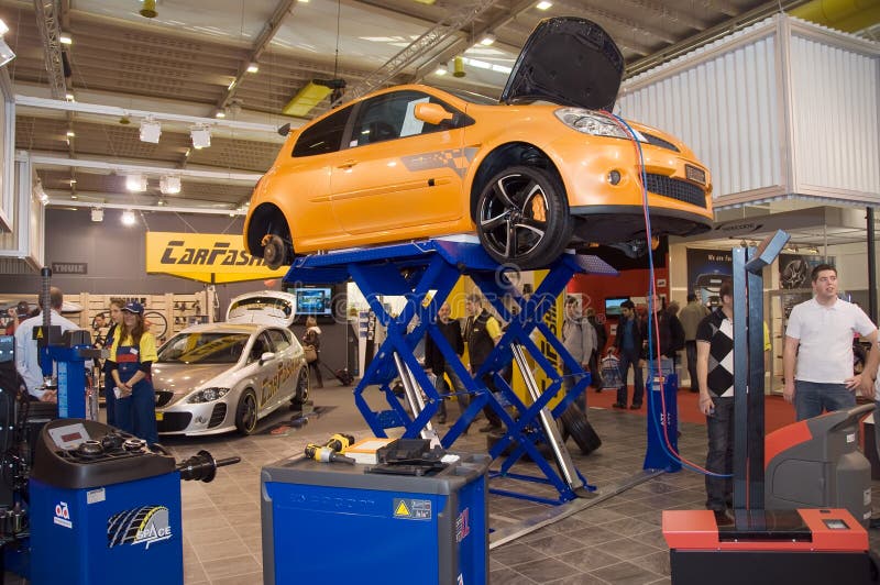 Geneva - 79th International Motor Show - 5th to 15th March 2009. Orange car on lifted on CarFashion.ch raiser. Geneva - 79th International Motor Show - 5th to 15th March 2009. Orange car on lifted on CarFashion.ch raiser.