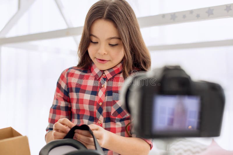 Vital advice. Lovely pre-teen girl showing how to regulate VR headset straps and recording it on the camera, making a video tutorial for her blog. Vital advice. Lovely pre-teen girl showing how to regulate VR headset straps and recording it on the camera, making a video tutorial for her blog