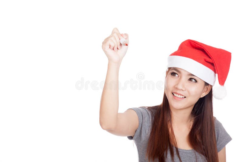 Den asiatiska flickan med den röda santa hatten skriver i luften och leendet