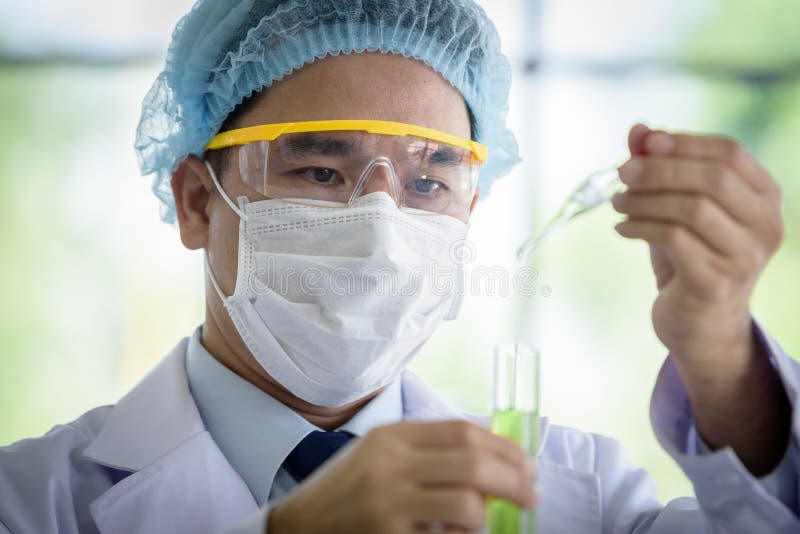 Den asiatiska h?ga forskaren har den undervisande unga studentforskaren i ett laboratorium fotografering för bildbyråer Den asiatiska h?ga forskaren har den undervisande unga studentforskaren i ett laboratorium fotografering för bildbyråer