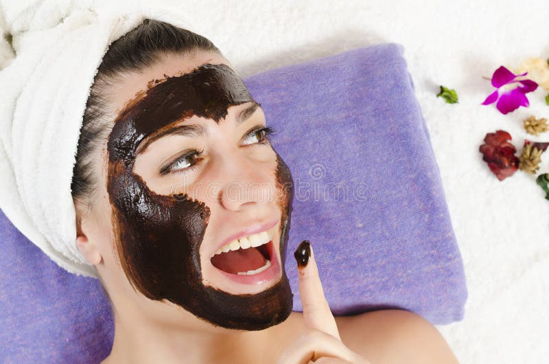 Attractive young woman getting a chocolate facial mask in the beauty spa. Attractive young woman getting a chocolate facial mask in the beauty spa