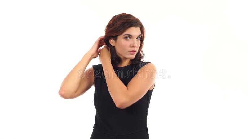 Den attraktiva unga kvinnan tiding hennes hår som ser i kameran som i spegeln och frågar för rådgivninganseende
