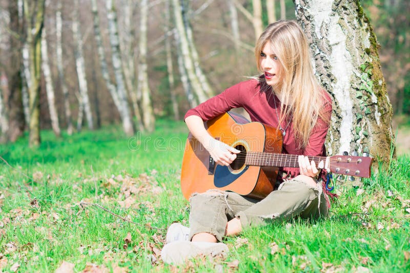 Den blonda flickan spelar gitarren arkivfoton Den blonda flickan spelar gitarren arkivfoton
