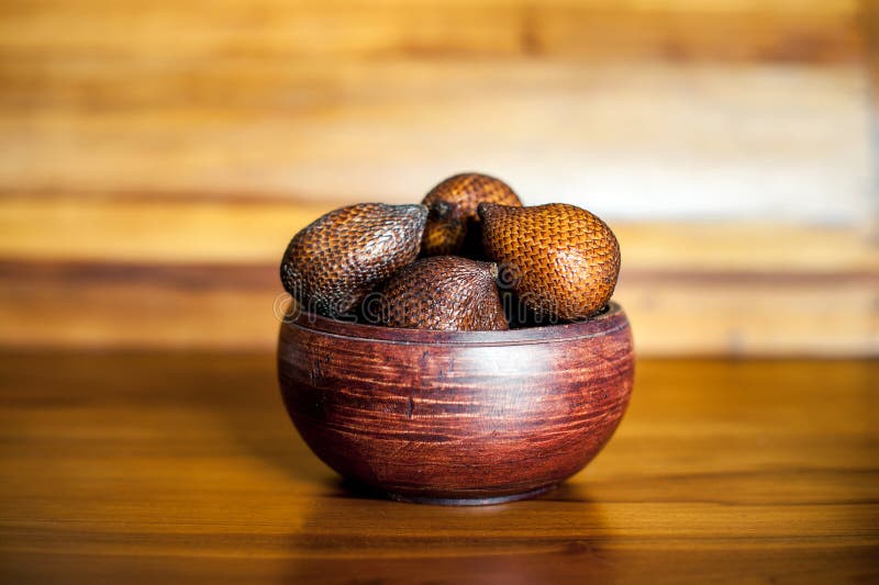 Den bruna träbunken med salak eller ormen bär frukt Exotiska nya frukter från Bali, Indonesien royaltyfri fotografi Den bruna träbunken med salak eller ormen bär frukt Exotiska nya frukter från Bali, Indonesien royaltyfri fotografi
