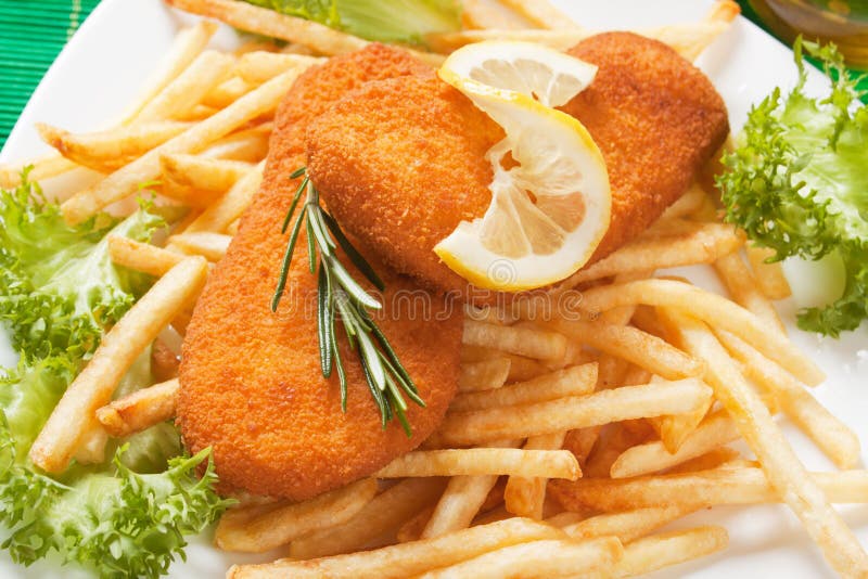 Panerade fiskbiffar med pommes frites arkivfoto