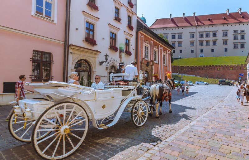 Den Cracow (Krakow) - Polen hästvagnen turnerar till den Wawel slotten royaltyfri fotografi Den Cracow (Krakow) - Polen hästvagnen turnerar till den Wawel slotten royaltyfri fotografi