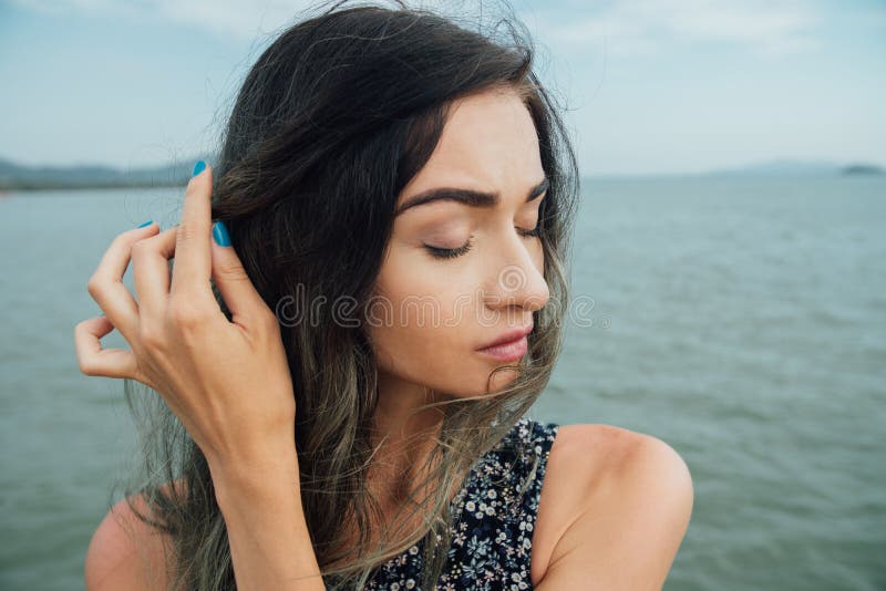 Den dystra stilfulla hipsterflickan rätar ut banden mot bakgrunden av havet i Asien royaltyfri fotografi Den dystra stilfulla hipsterflickan rätar ut banden mot bakgrunden av havet i Asien royaltyfri fotografi