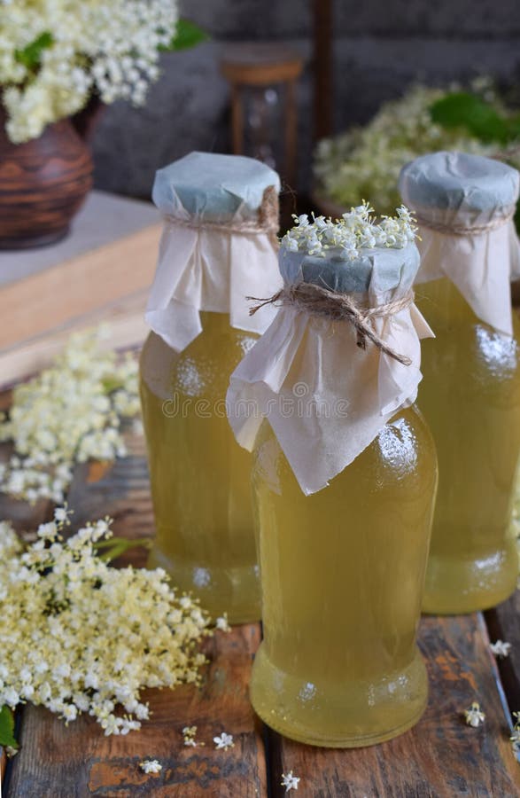 Den Elderflower blommar innerlig sirap och blomningen i träbakgrund Ätliga fläderbärblommor tillfogar anstrykning och arom till d royaltyfri fotografi Den Elderflower blommar innerlig sirap och blomningen i träbakgrund Ätliga fläderbärblommor tillfogar anstrykning och arom till d royaltyfri fotografi