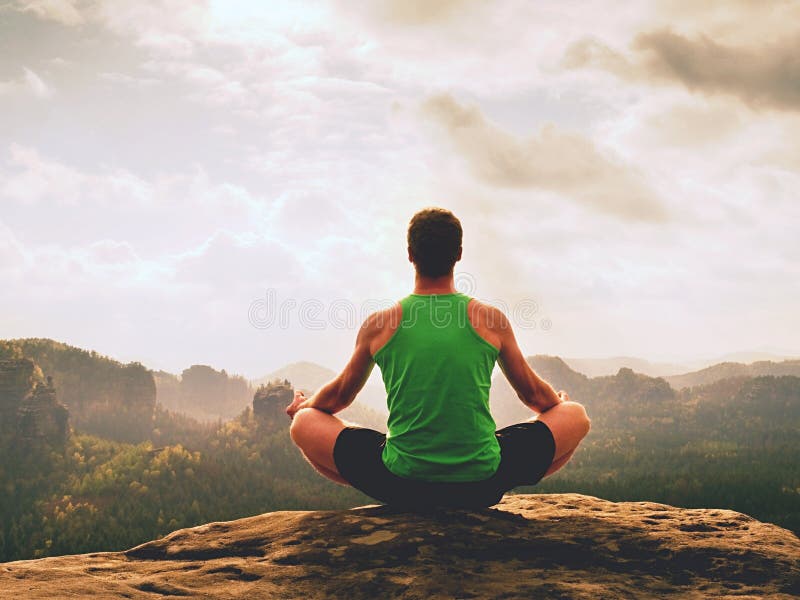 Den ensamma mannen gör yoga poserar på vaggar maximumet inom dimmig morgon Praktiserande yoga för medelålders man royaltyfri fotografi Den ensamma mannen gör yoga poserar på vaggar maximumet inom dimmig morgon Praktiserande yoga för medelålders man royaltyfri fotografi