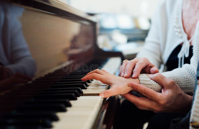 Den erfarna handen av den gamla musikläraren hjälper barneleven royaltyfria bilder Den erfarna handen av den gamla musikläraren hjälper barneleven royaltyfria bilder
