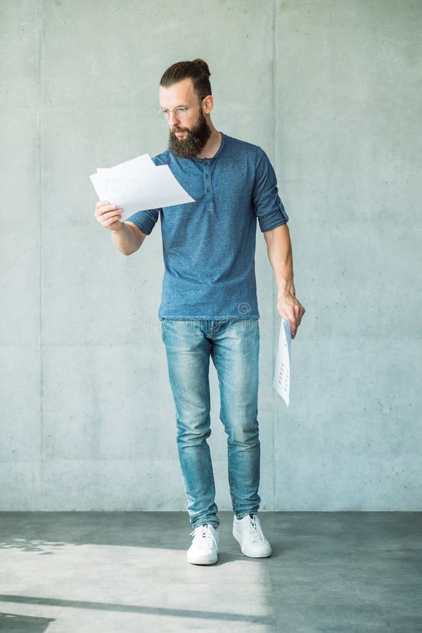 Den fokuserade mannen läste för informationsrapport om dokument data arkivfoto Den fokuserade mannen läste för informationsrapport om dokument data arkivfoto