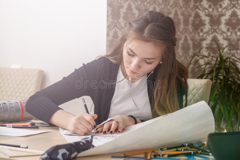 Den Frontal ståenden av en ung kvinnlig student är förlovad på tabellattraktionerna skissar, skissar, plan, arkitektur utbildning royaltyfri fotografi Den Frontal ståenden av en ung kvinnlig student är förlovad på tabellattraktionerna skissar, skissar, plan, arkitektur utbildning royaltyfri fotografi
