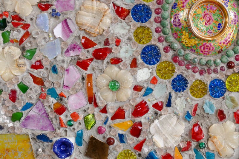 Den färgrika brutna tegelplattan, pärlan, bunken och stenen som dekorerar på tem