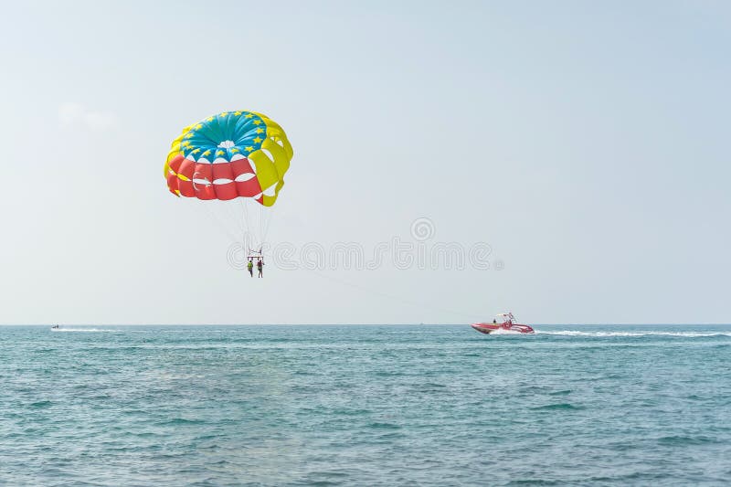 Den färgrika parasailvingen drog vid ett fartyg i havsvattnet - Alanya, Turkiet royaltyfri bild Den färgrika parasailvingen drog vid ett fartyg i havsvattnet - Alanya, Turkiet royaltyfri bild