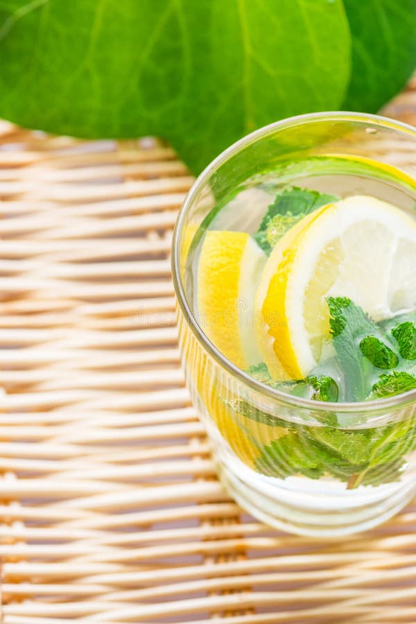 Den förnyande detoxen ingav sassy vatten med ingefäran för den nya mintkaramellen för citronen i exponeringsglas på den vide- tab royaltyfri fotografi Den förnyande detoxen ingav sassy vatten med ingefäran för den nya mintkaramellen för citronen i exponeringsglas på den vide- tab royaltyfri fotografi