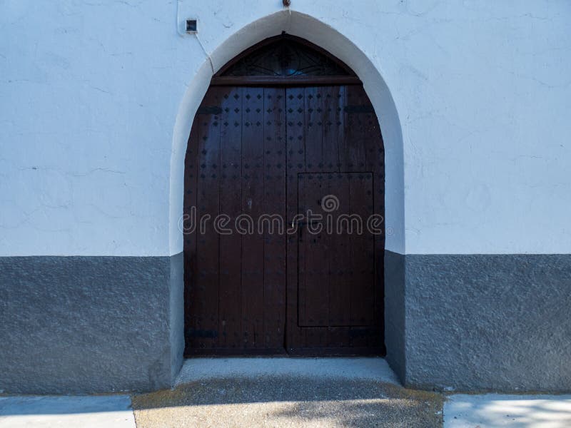 Den gamla tr?porten fixade med stora m?ssingsnitar i Cordoba, Andalusia, Spanien arkivfoto Den gamla tr?porten fixade med stora m?ssingsnitar i Cordoba, Andalusia, Spanien arkivfoto