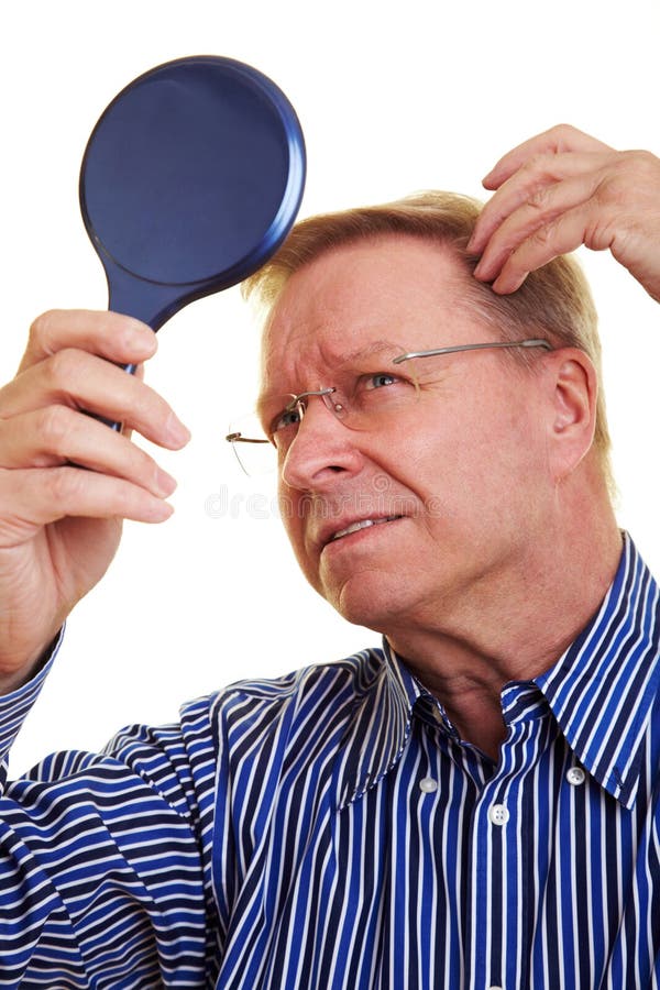 Eldery man watching his receding hair line in mirror. Eldery man watching his receding hair line in mirror