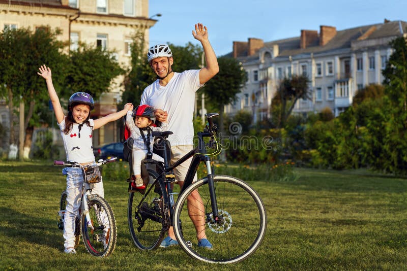 Den gladlynta familjen som in cyklar, parkerar arkivbild Den gladlynta familjen som in cyklar, parkerar arkivbild