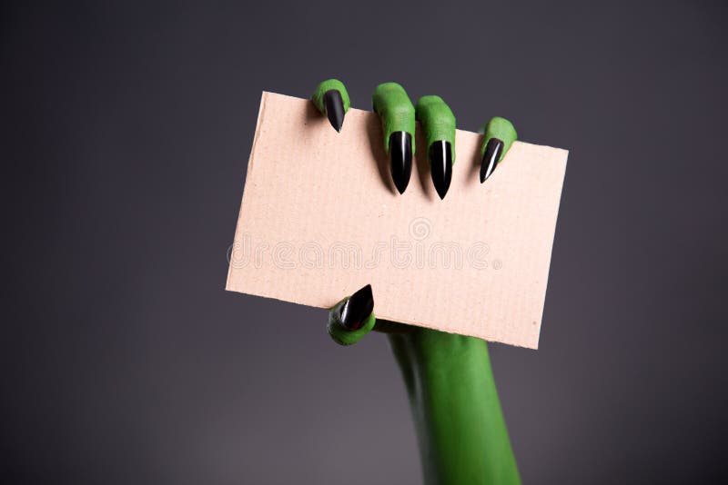 Den gröna gigantiska handen med kors spikar innehavmellanrumsstycket av cardb