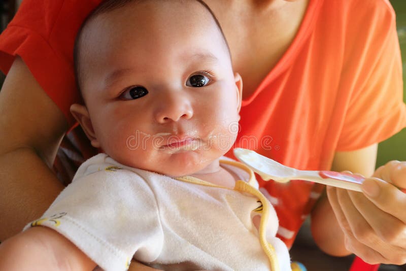 Den gulliga asiatet behandla som ett barn pojken som den nyfödda äta frossaren av matande mattillägg för modern för behandla som arkivfoto Den gulliga asiatet behandla som ett barn pojken som den nyfödda äta frossaren av matande mattillägg för modern för behandla som arkivfoto