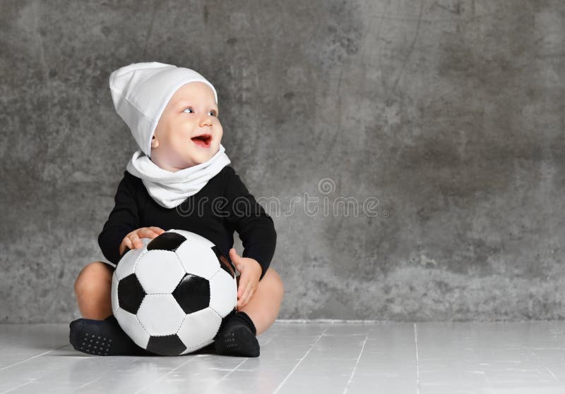 Den gulliga bilden av behandla som ett barn rymma en fotbollboll royaltyfria bilder Den gulliga bilden av behandla som ett barn rymma en fotbollboll royaltyfria bilder