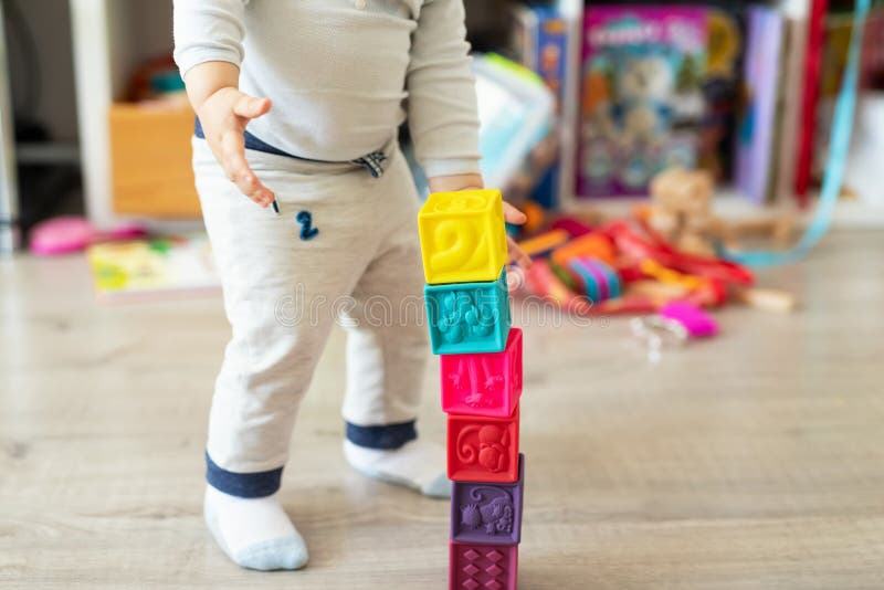 Den gulliga f?rtjusande caucasianen behandla som ett barn pojken som hemma spelar f?rgrik leksaker Lyckligt barn som har det roli royaltyfri fotografi Den gulliga f?rtjusande caucasianen behandla som ett barn pojken som hemma spelar f?rgrik leksaker Lyckligt barn som har det roli royaltyfri fotografi