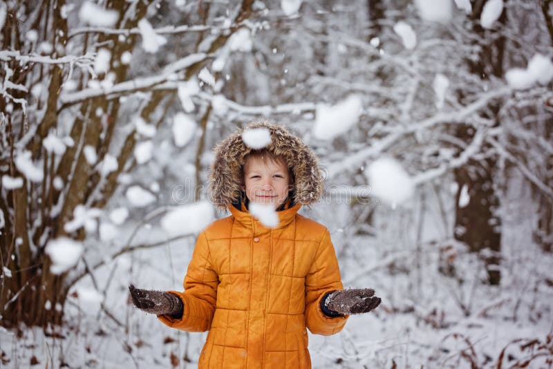 Den gulliga pysen, unge i vinter beklär att gå under den insnöade vintern parkerar royaltyfria bilder Den gulliga pysen, unge i vinter beklär att gå under den insnöade vintern parkerar royaltyfria bilder