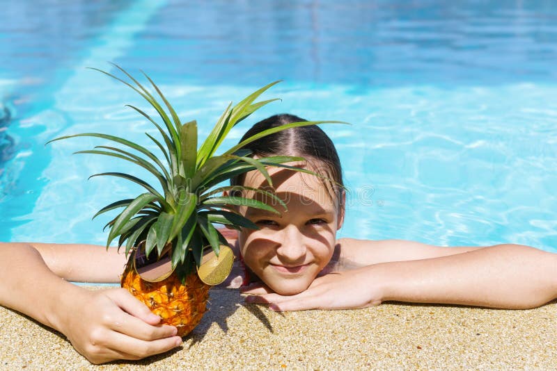 Den gulliga tonåriga flickan kramar ananas i solglasögon på poolsiden Resor semester Textutrymme arkivbild