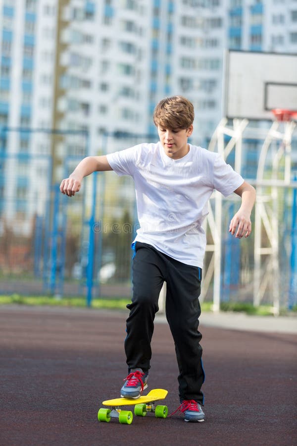 Den gulliga unga sportpojken som åker skridskor på den gula skateboarden och, har en bra tid på hans fria tid på helg, semestrar arkivfoto Den gulliga unga sportpojken som åker skridskor på den gula skateboarden och, har en bra tid på hans fria tid på helg, semestrar arkivfoto