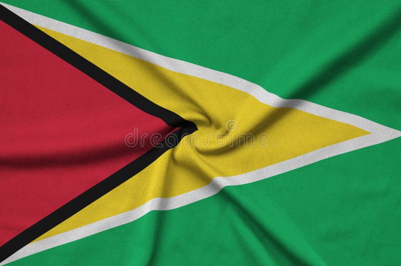 Den Guyana flaggan visas på ett sporttorkduketyg med många veck Baner för sportlag royaltyfria foton Den Guyana flaggan visas på ett sporttorkduketyg med många veck Baner för sportlag royaltyfria foton