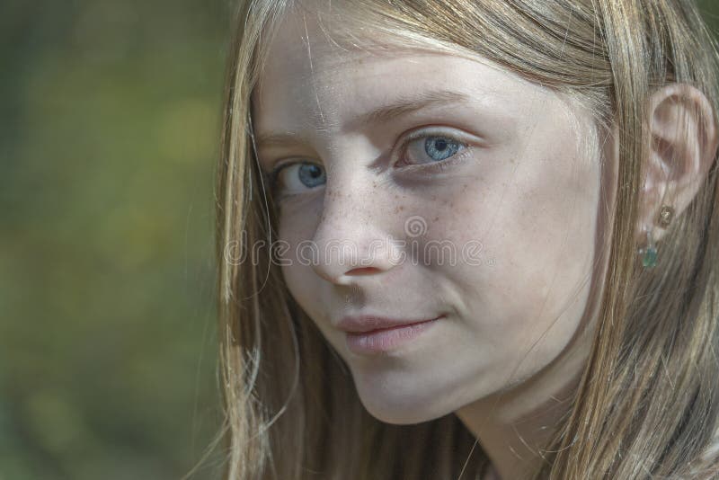 Den h?rliga blonda unga flickan med fr?knar utomhus p? naturbakgrund i h?st, st?nger sig upp st?enden royaltyfri bild Den h?rliga blonda unga flickan med fr?knar utomhus p? naturbakgrund i h?st, st?nger sig upp st?enden royaltyfri bild