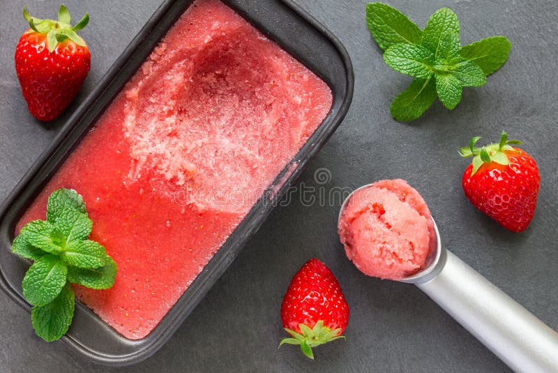Homemade strawberry sorbet in tray on a gray slate. Homemade strawberry sorbet in tray on a gray slate