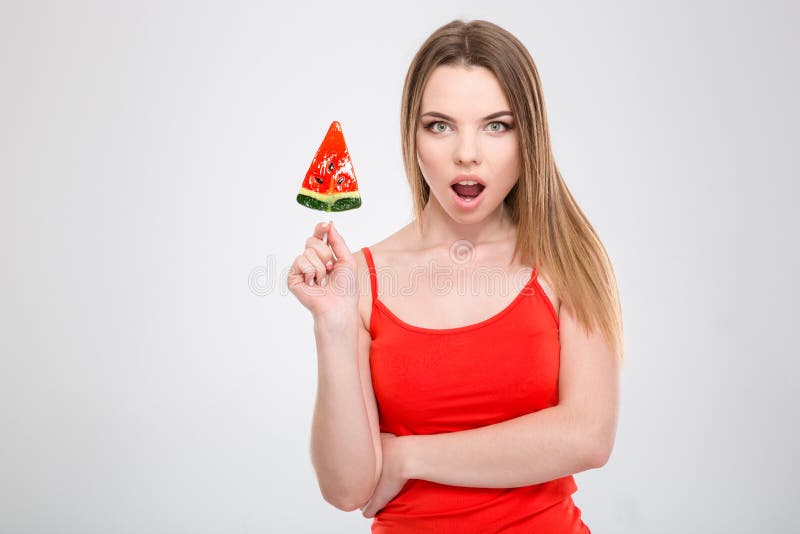 Den häpna upphetsade unga kvinnliga hållande vattenmelon formade lollypop arkivfoto Den häpna upphetsade unga kvinnliga hållande vattenmelon formade lollypop arkivfoto